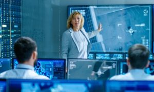 In the Government Surveillance Facility Team of Officers Organize Interception Plan with Help of Satellite Navigation. Big Screen Shows Top Down Images of the Target's Car.